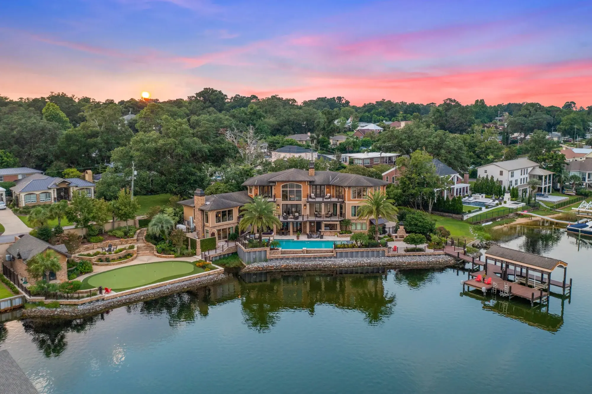 Waterfront luxury on Bayou Texar awaits at this lavish home with water views, direct outdoor access from all levels, an infinity-edge pool & putting green, & private boat dock.