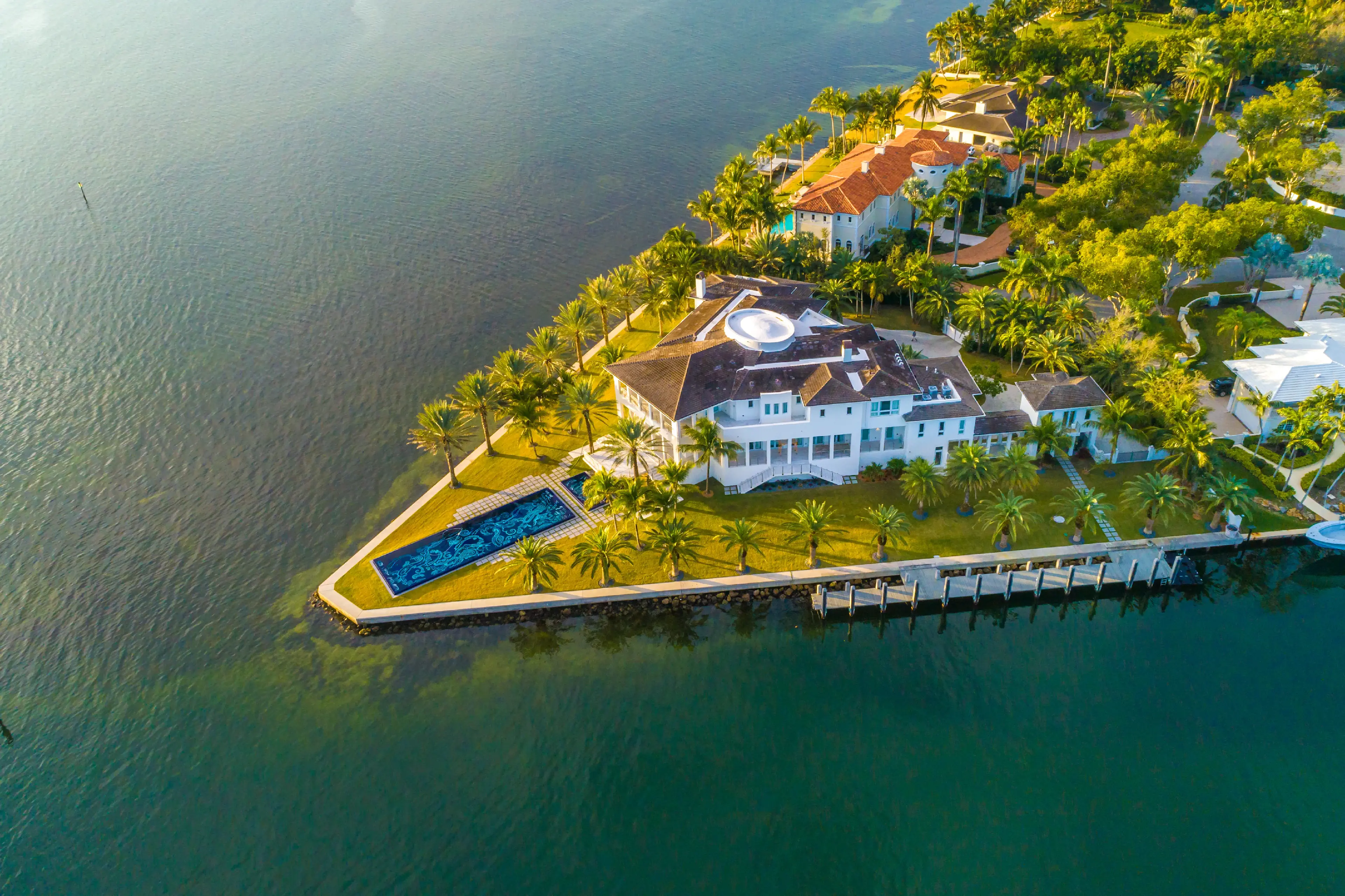 Beyond the contemporary gates rests a palatial waterfront oasis, a playground of sun-filled days and glamorous nights. Imagine glittering formal galas spilling from the magnificent chandelier-lit foyer to the sleek interior bar and beyond to expansive wat