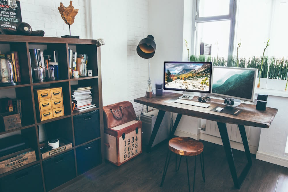 home office with shelving unit and old case with numbers beside desk
