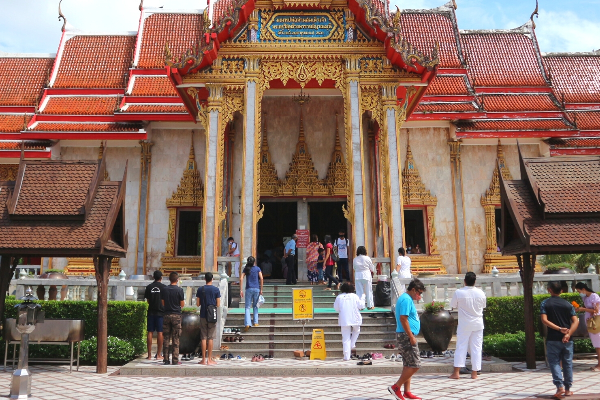 People taking off shoes at entrance of Wat Chaithararam (Wat Chalong) in Phuket, Thailand