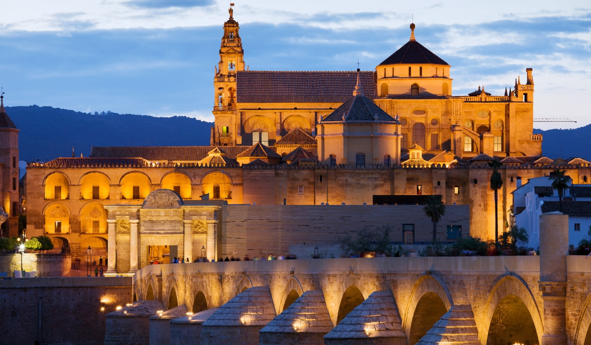 Mosque-Cathedral, Mezquita-Catedral of Córdoba and Roman Bridge at night in Spain