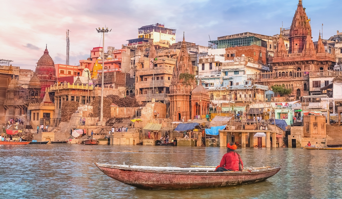 View of Varanasi ancient city and sadhu baba on a boat on river Ganges in India