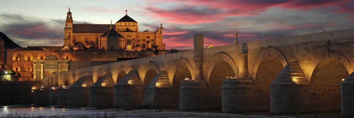 Roman Bridge, old bridge, over Guadalquivir river at night in Córdoba, Spain