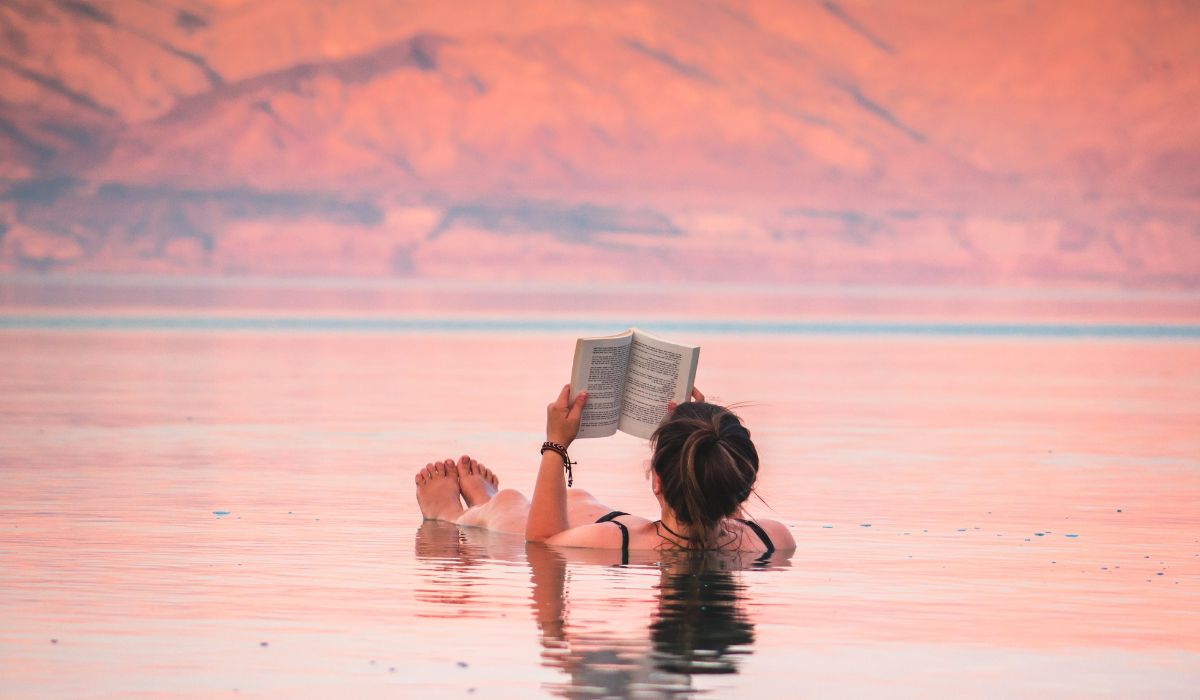 Person reading a book while floating in the Dead Sea in Jordan