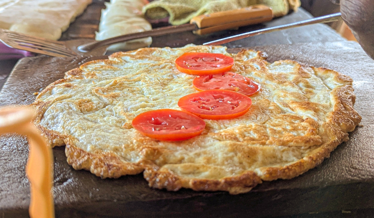 Fried eggs and tomato for Ugandan Rolex food