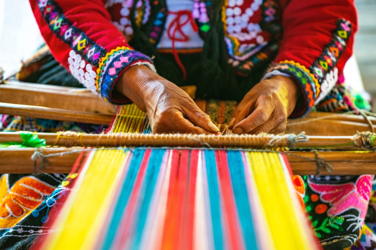 Indigenous Quechua woman weaving textiles