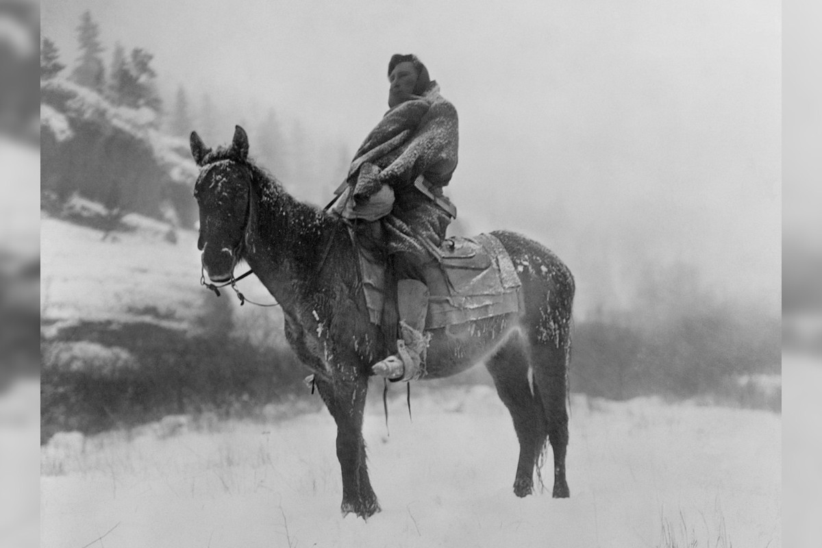 Crow tribe scout on a horse on snow-covered ground in Montana, 1908