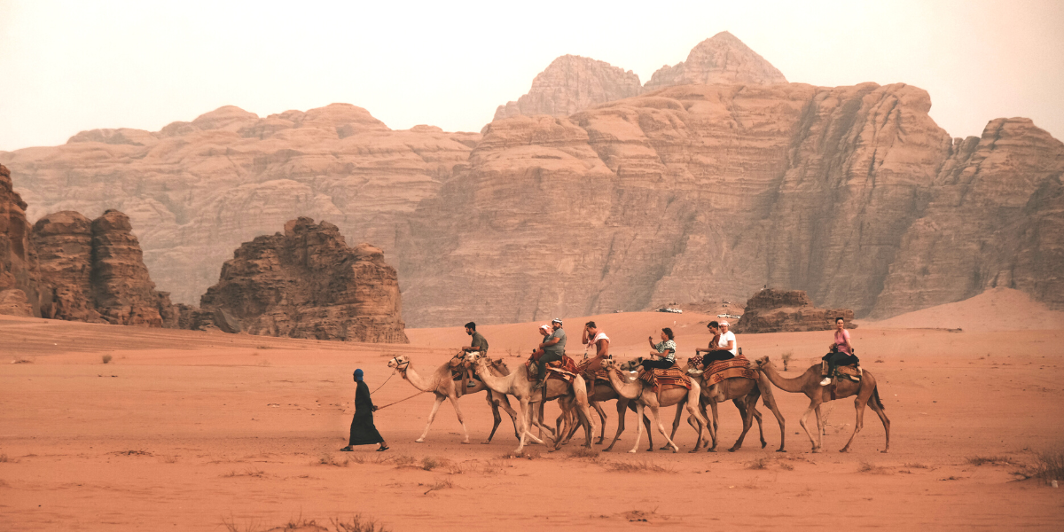 Tourists riding camels in the Wadi Rum desert in Jordan
