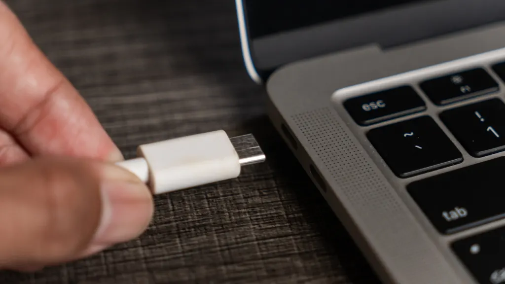 Lifestyle image of hand plugging in USBC plug into a laptop