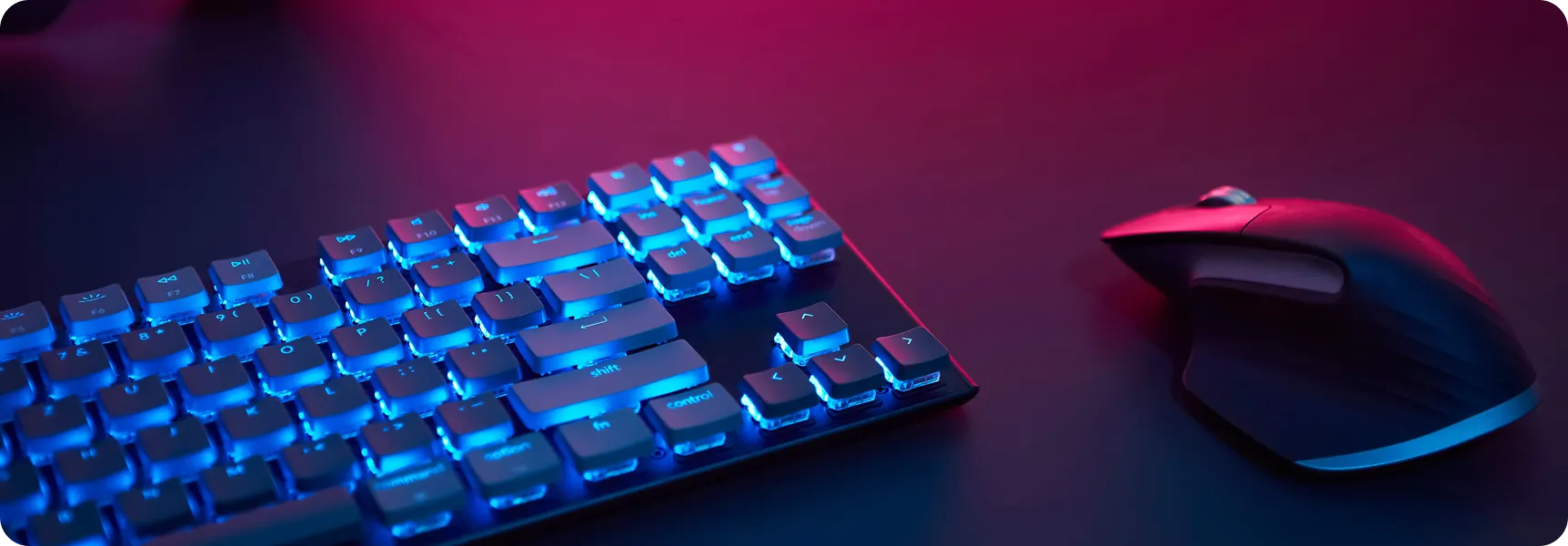 Wireless keyboard and mouse on a desk with colorful lighting