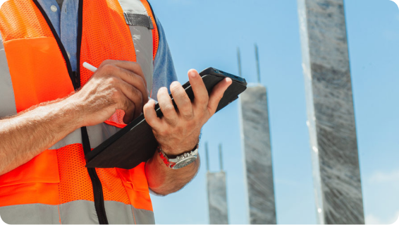 A construction worker out in the field on his tablet