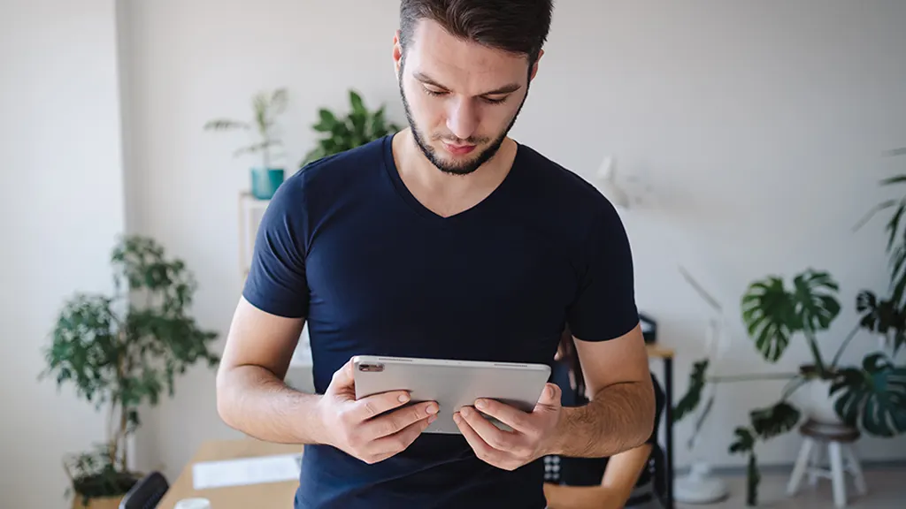 Man looking at iPad that's running slowly