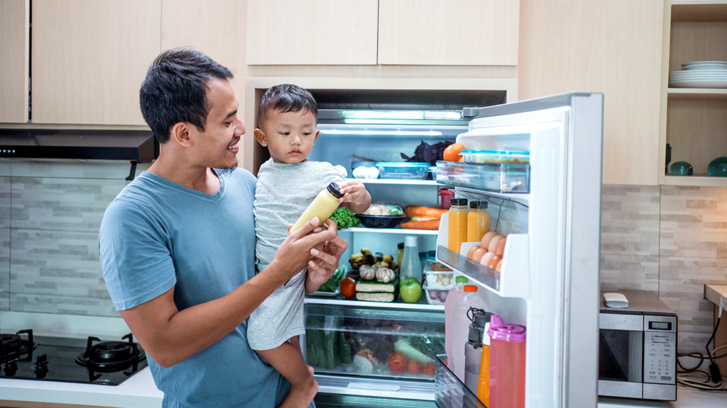 Father and son looking for food in refrigerator
