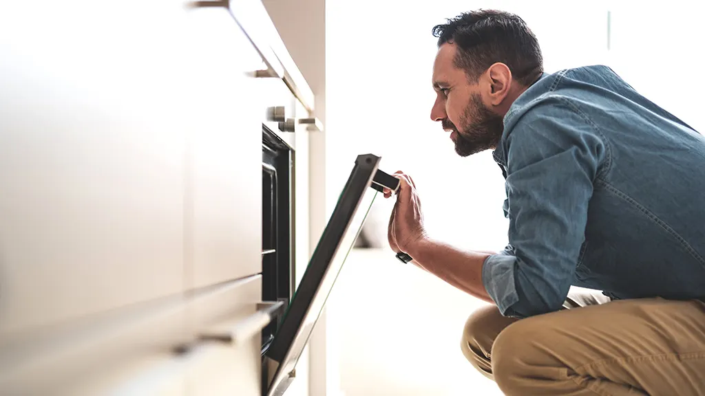 Man looking into oven that's not heating up