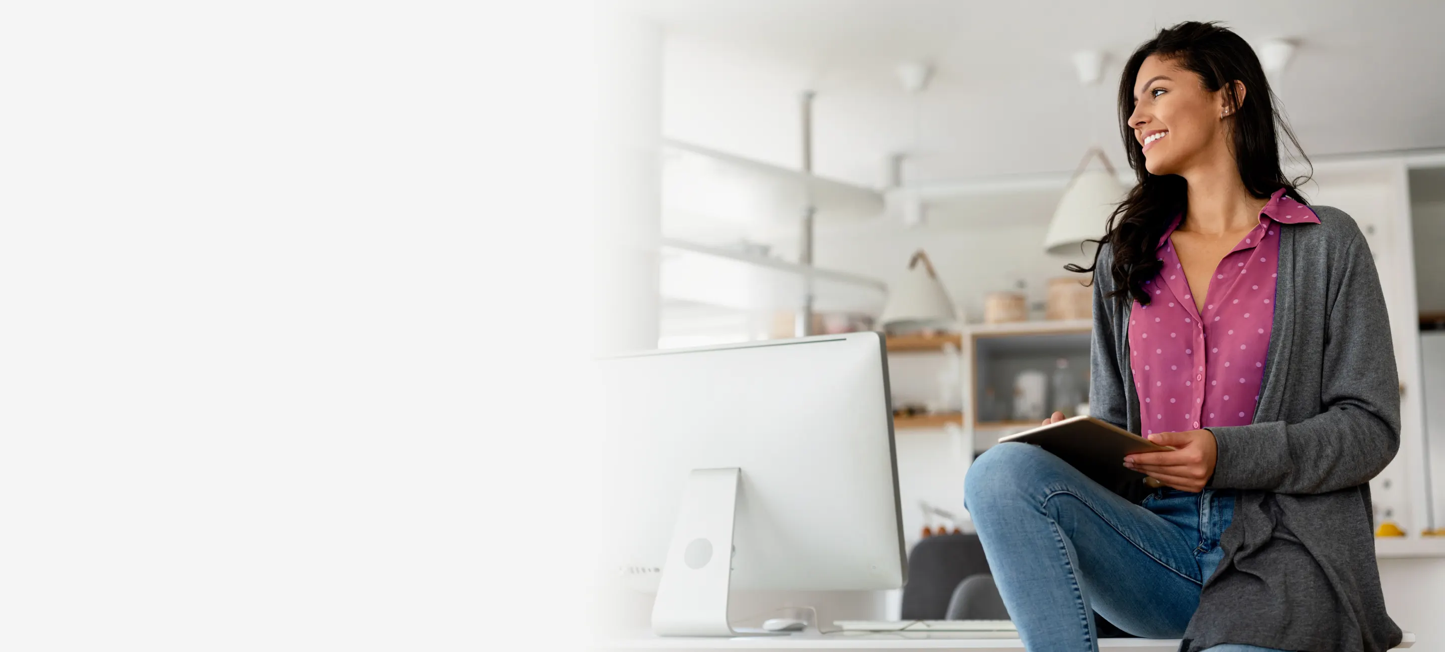 Woman sitting on a desk with a computer 