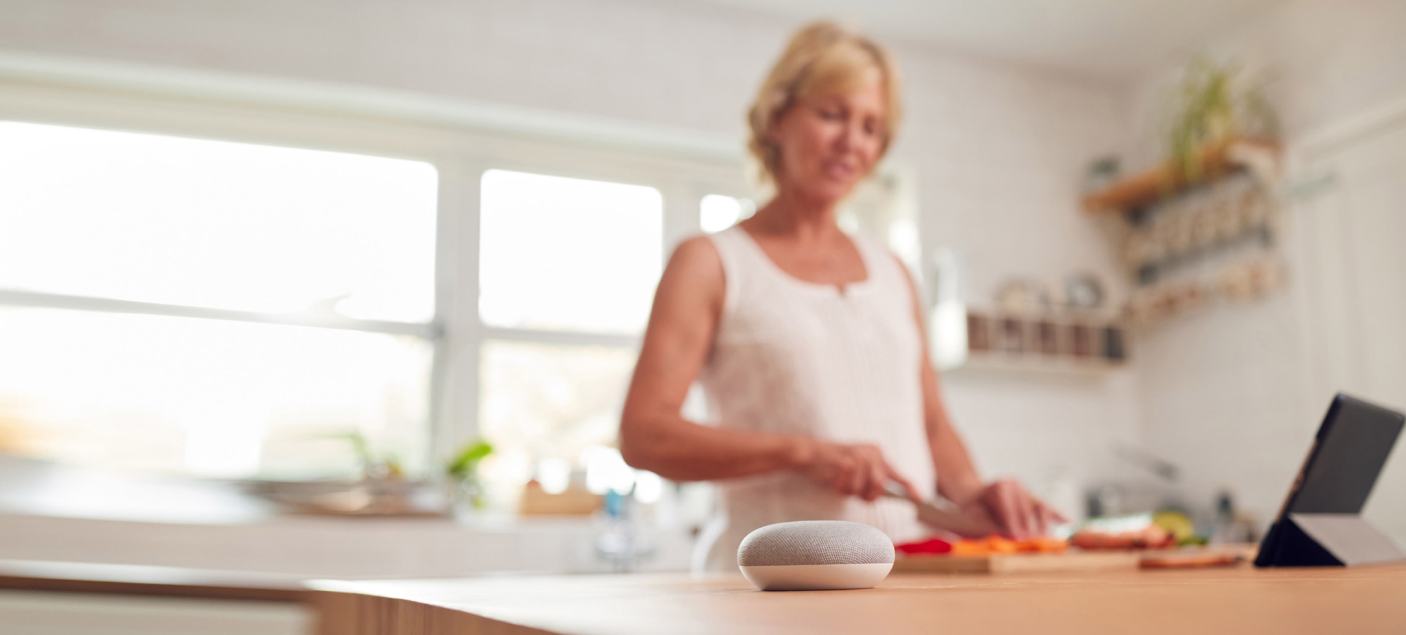 woman preparing food with smart speaker on table