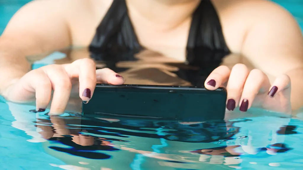 Woman using waterproof phone in pool