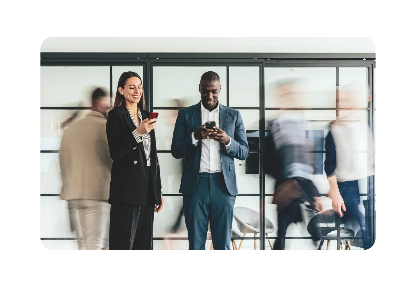 Man and woman using their phones in a busy area