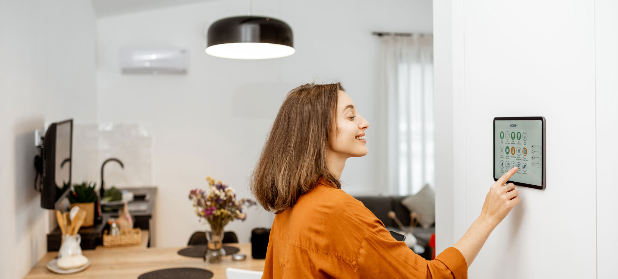 Woman controlling smart home devices using a digital tablet 