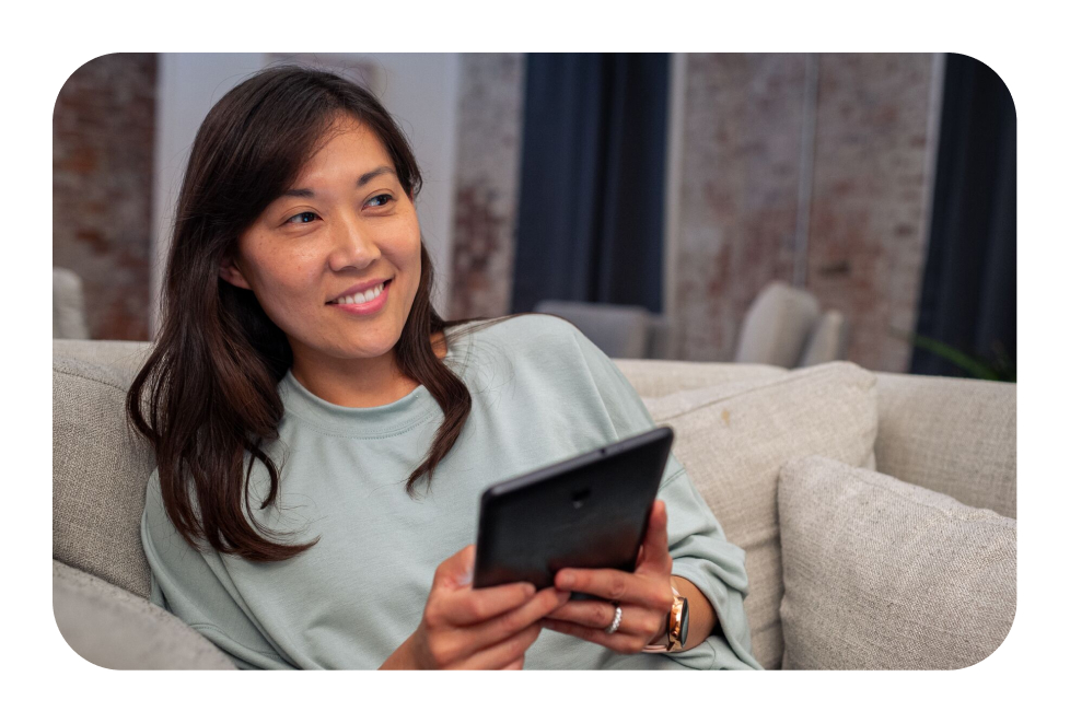 Woman holding a tablet looking off at the distance