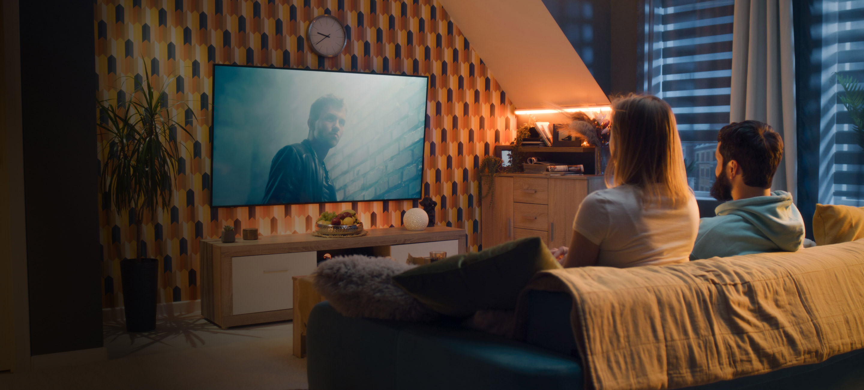 Family sitting on couch watching TV