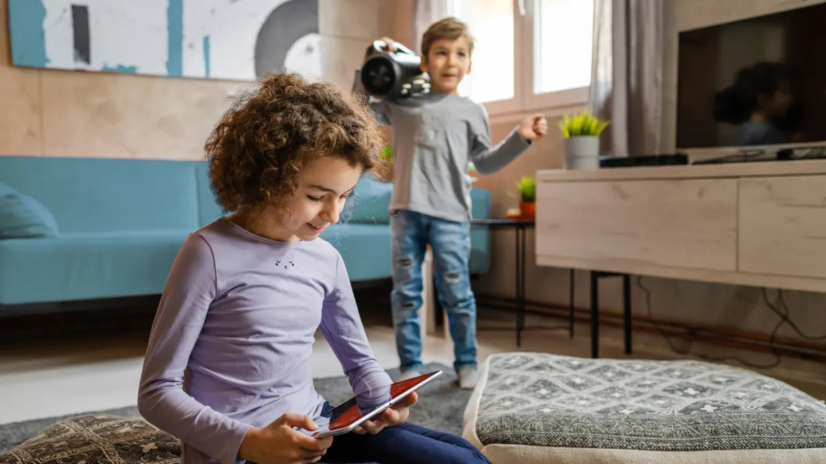 Kids enjoying tablet and speakers at home which is under AT&T Home Tech Protection Coverage