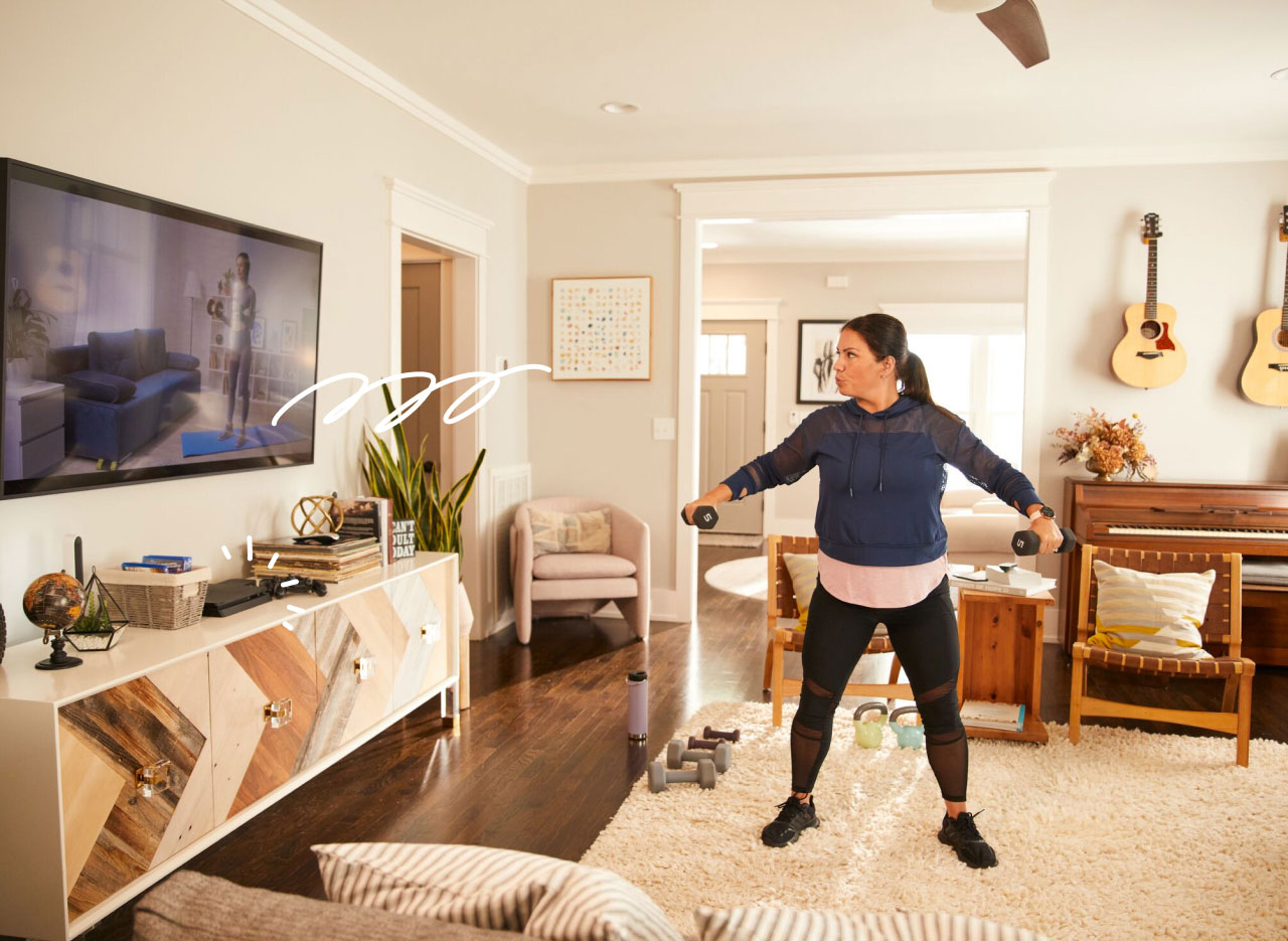 Woman working out at home, doing exercise in front of television at home.