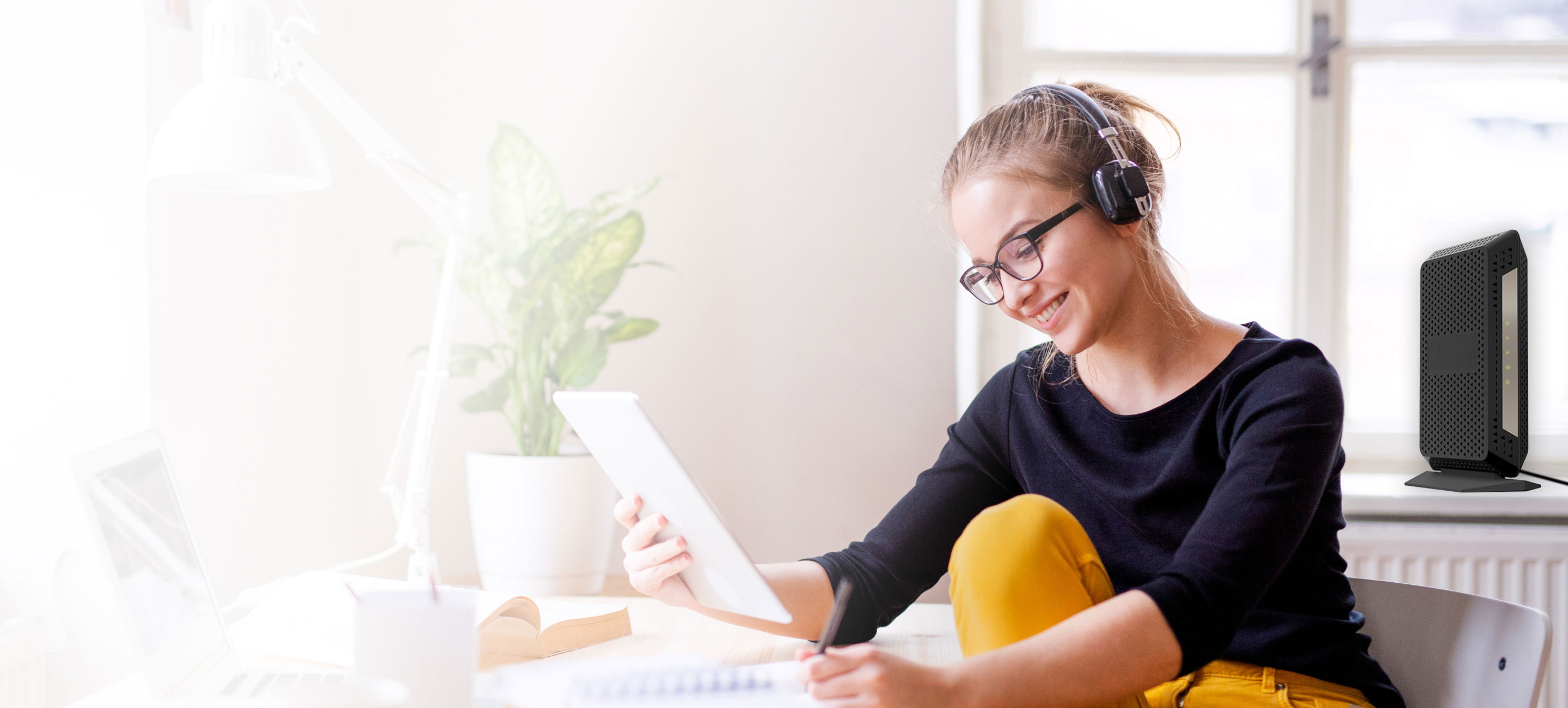 woman looking at tablet with a modem in background