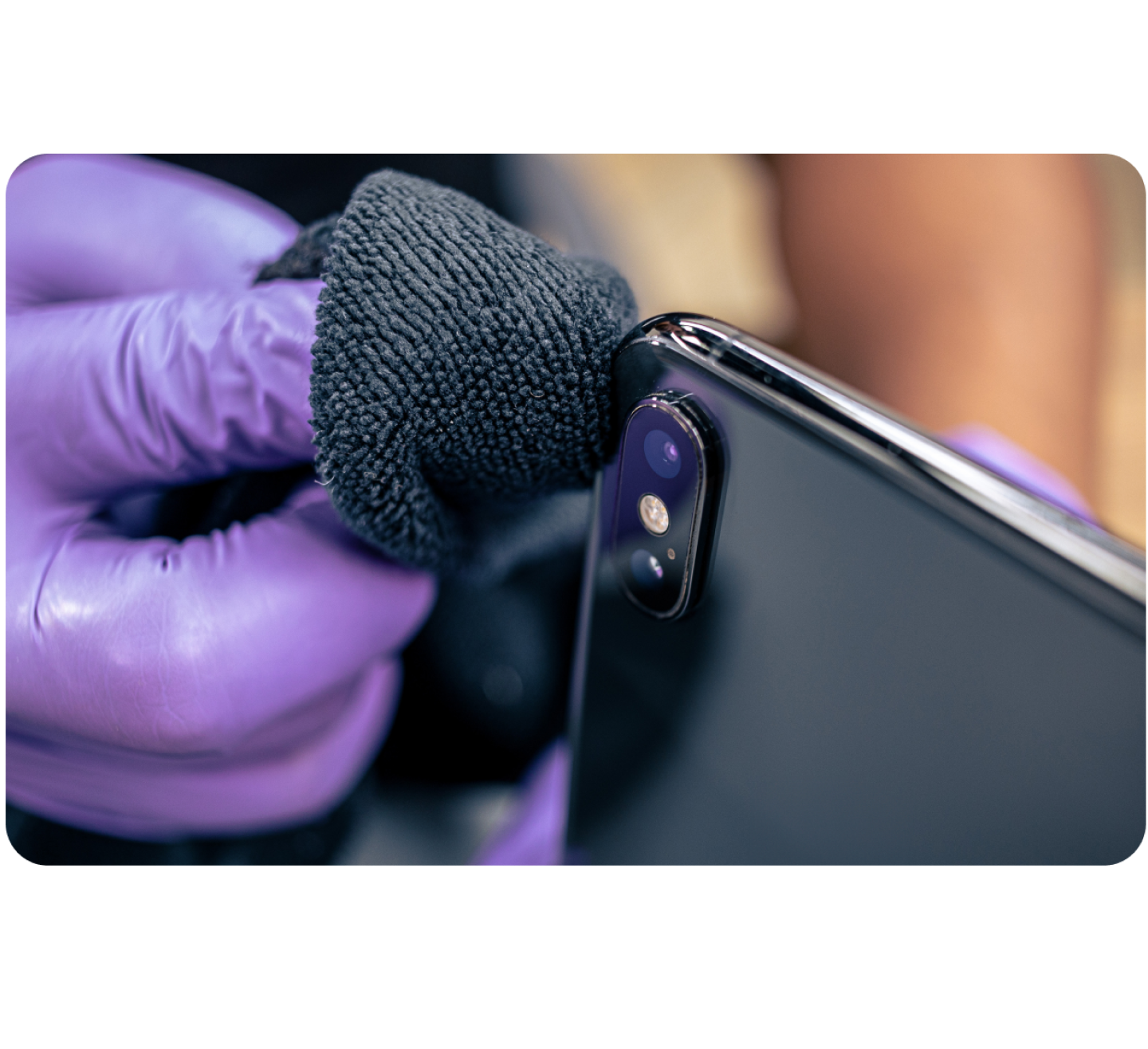Gloved hand cleaning a smartphone