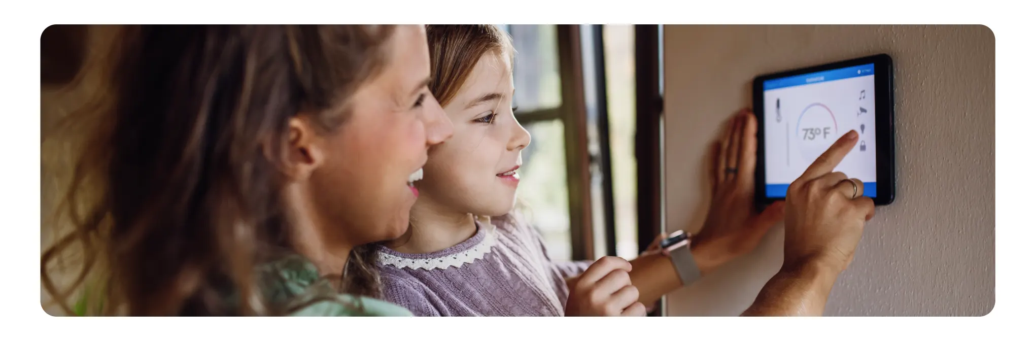 Mom and daughter using thermostat