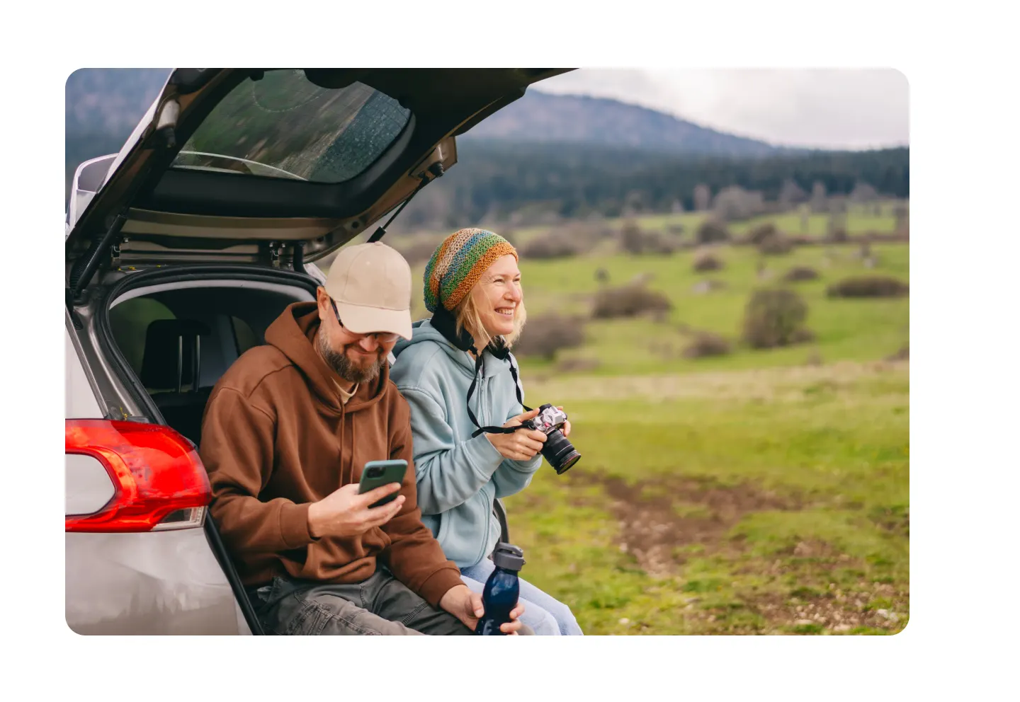 Couple sitting in back of car in fall