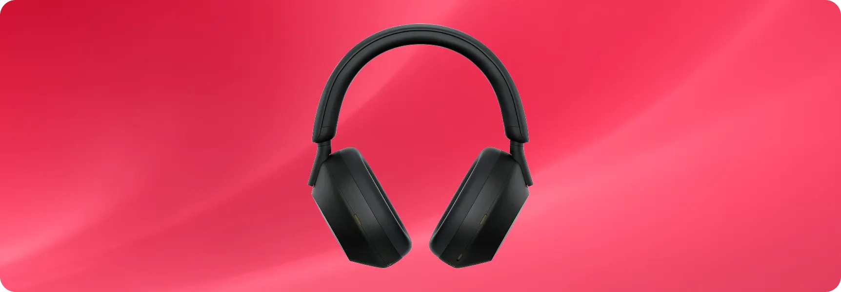 Black over-ear noise-canceling headphones on a red background.