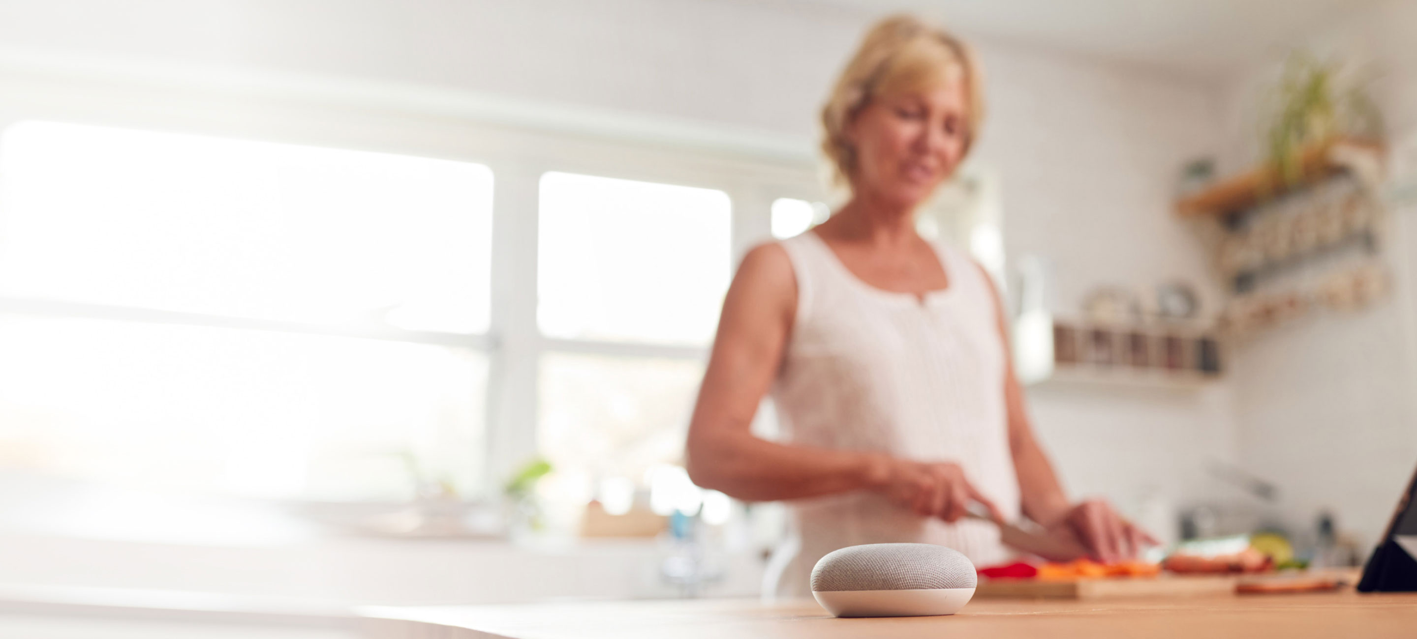 woman preparing food with smart speaker on table