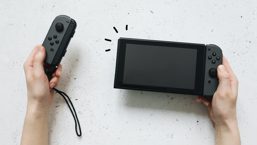 Person holding Nintendo Switch console and controller