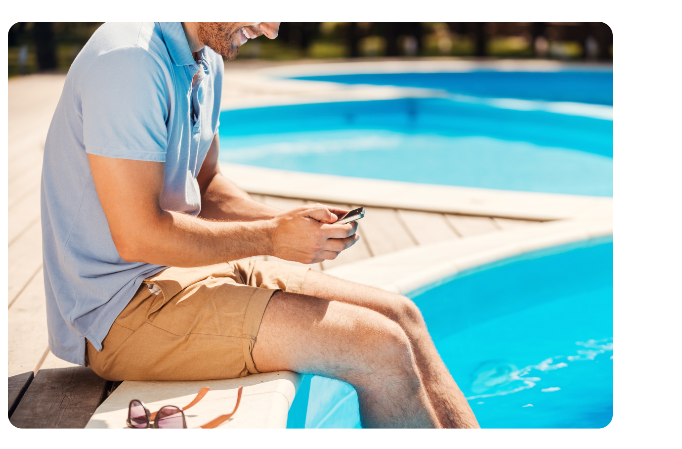 Sitting by pool using phone