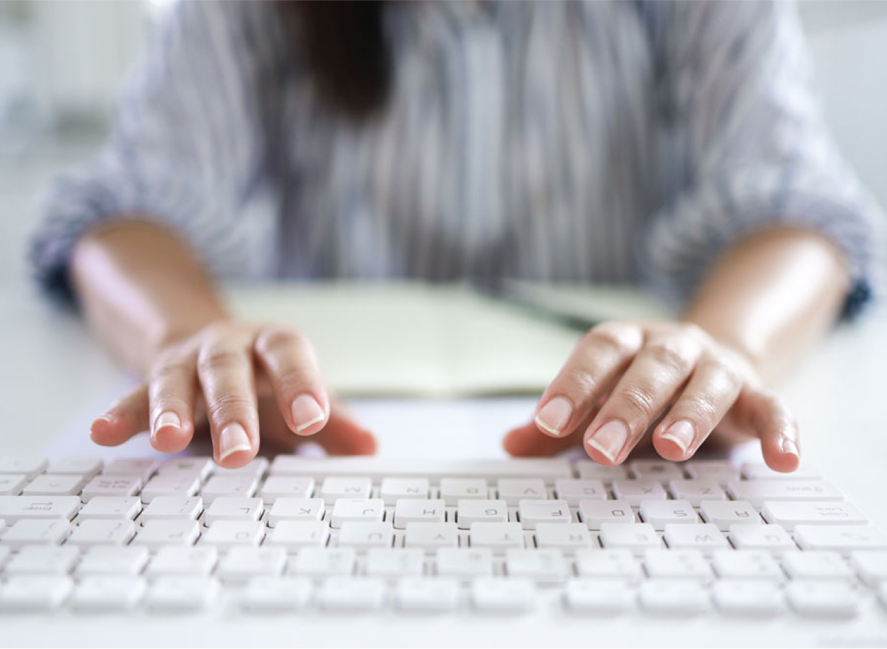 Woman hands typing on desktop keyboard