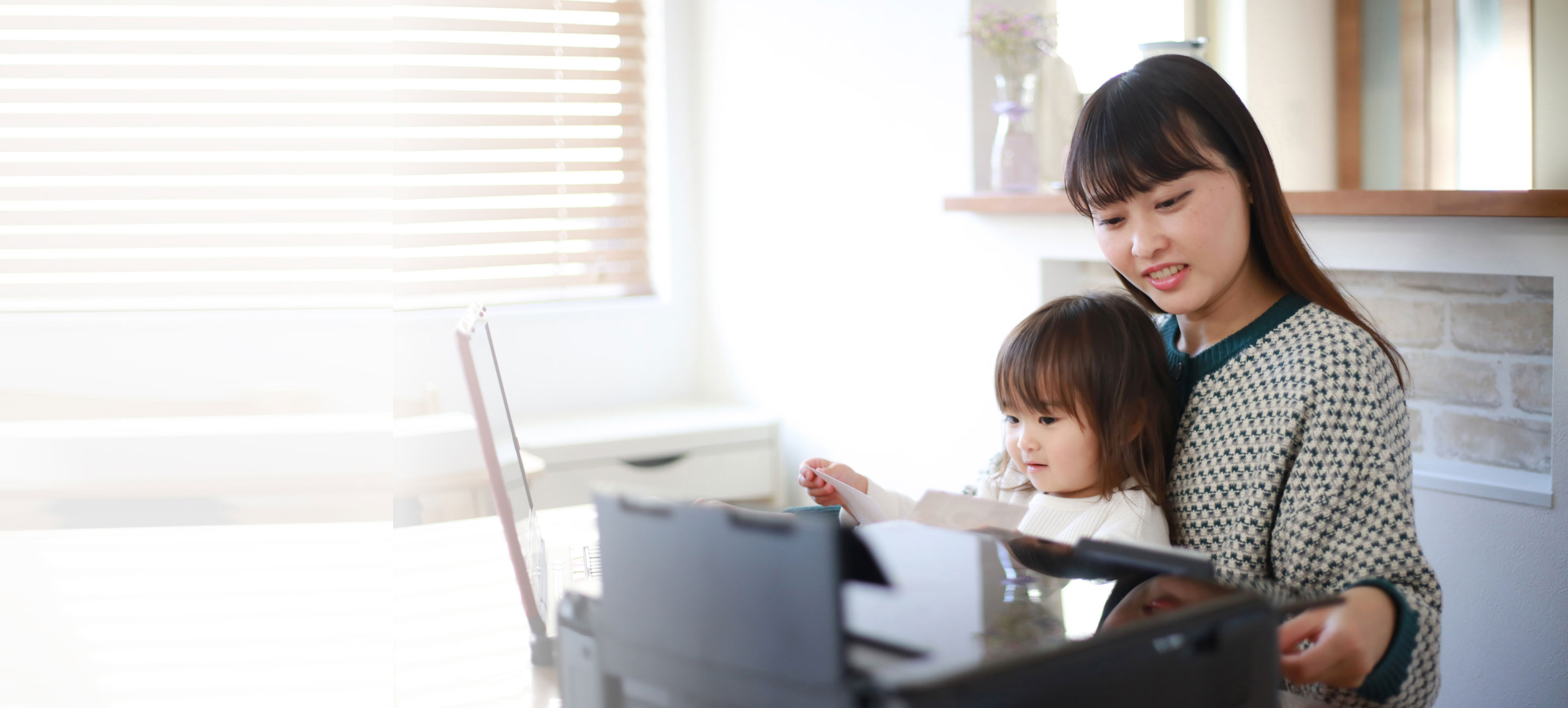 mom and daughter in home office room with printer