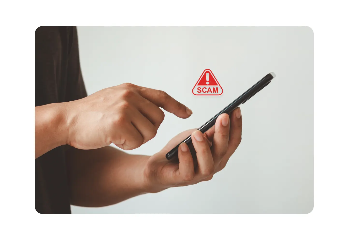 Person using a smartphone with a scam alert icon, highlighting phishing scams, fraudulent messages, and mobile security awareness.