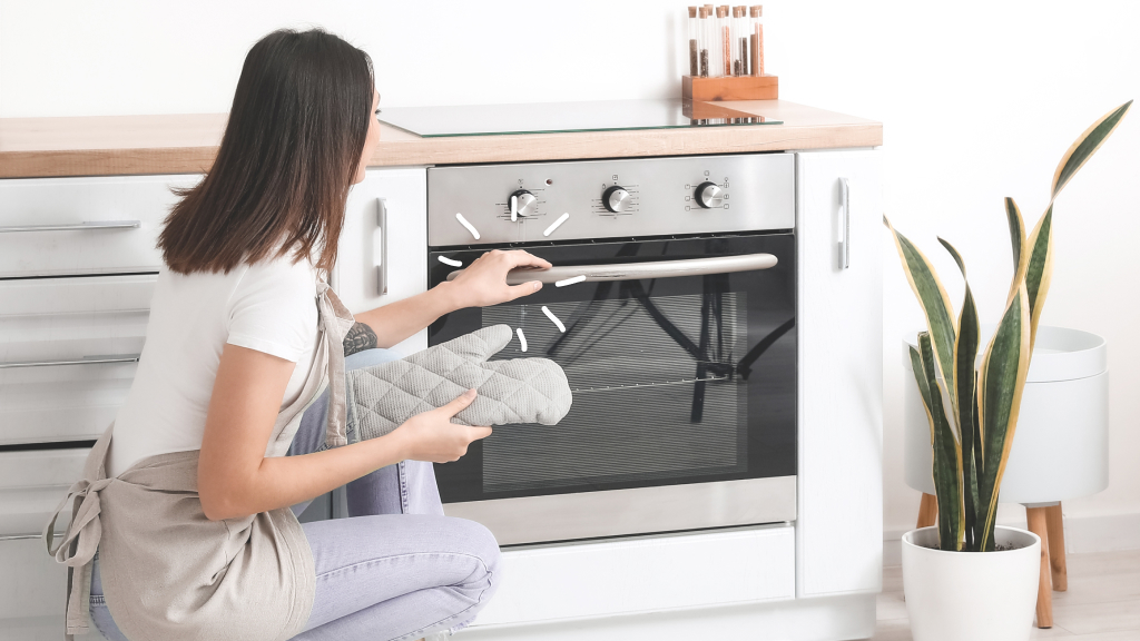Woman looking at stove considering appliance service plans