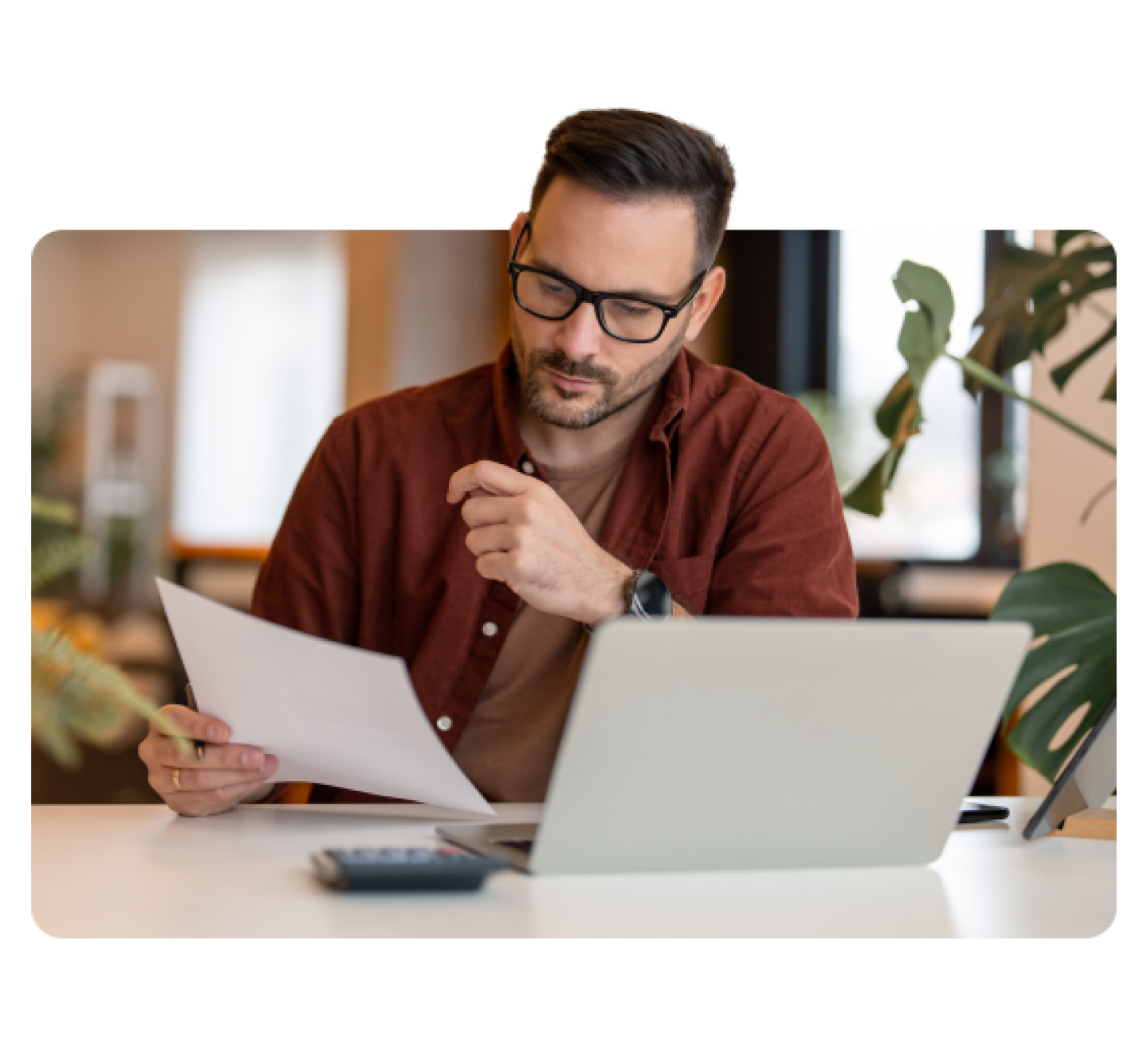 Man in front of laptop with calculator and paper