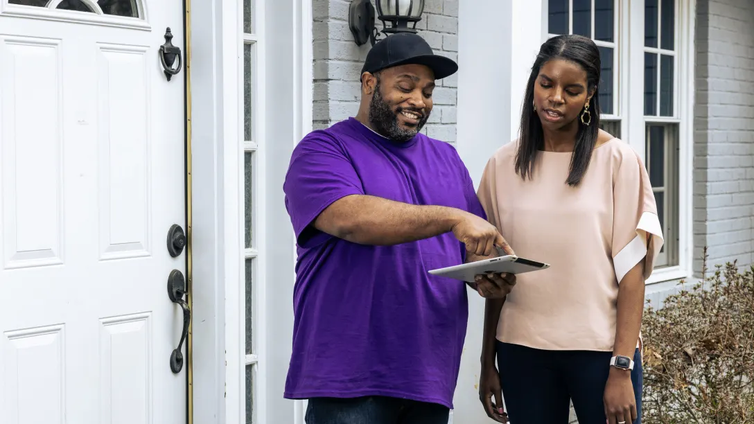 Tech expert tapping on the tablet and talking to a customer