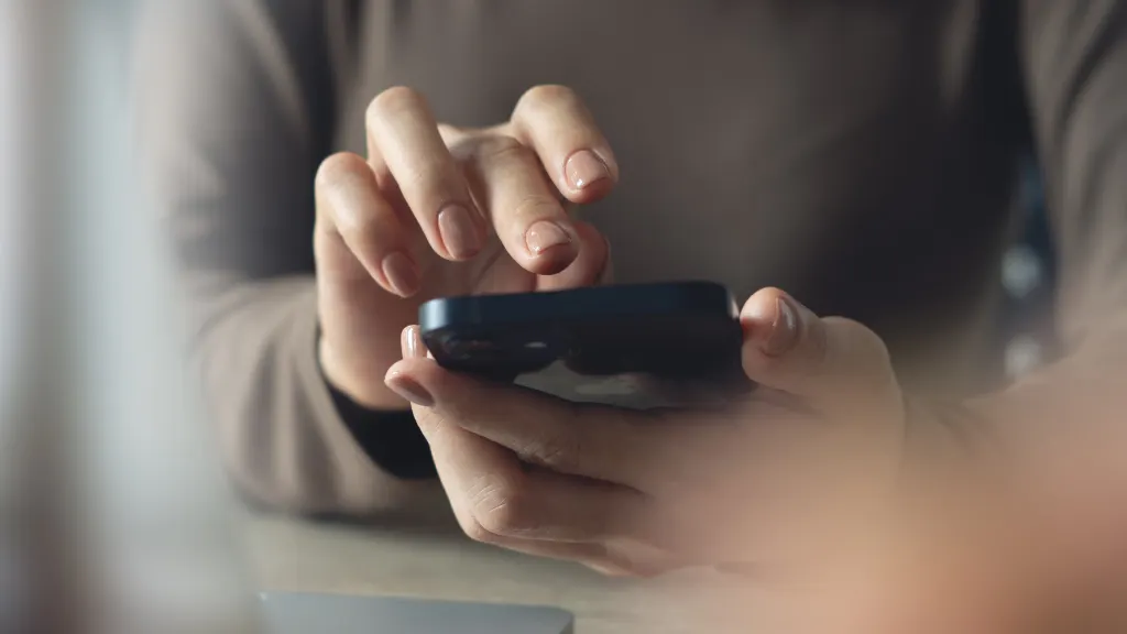 Close-up of feminine hands holding a black smartphone