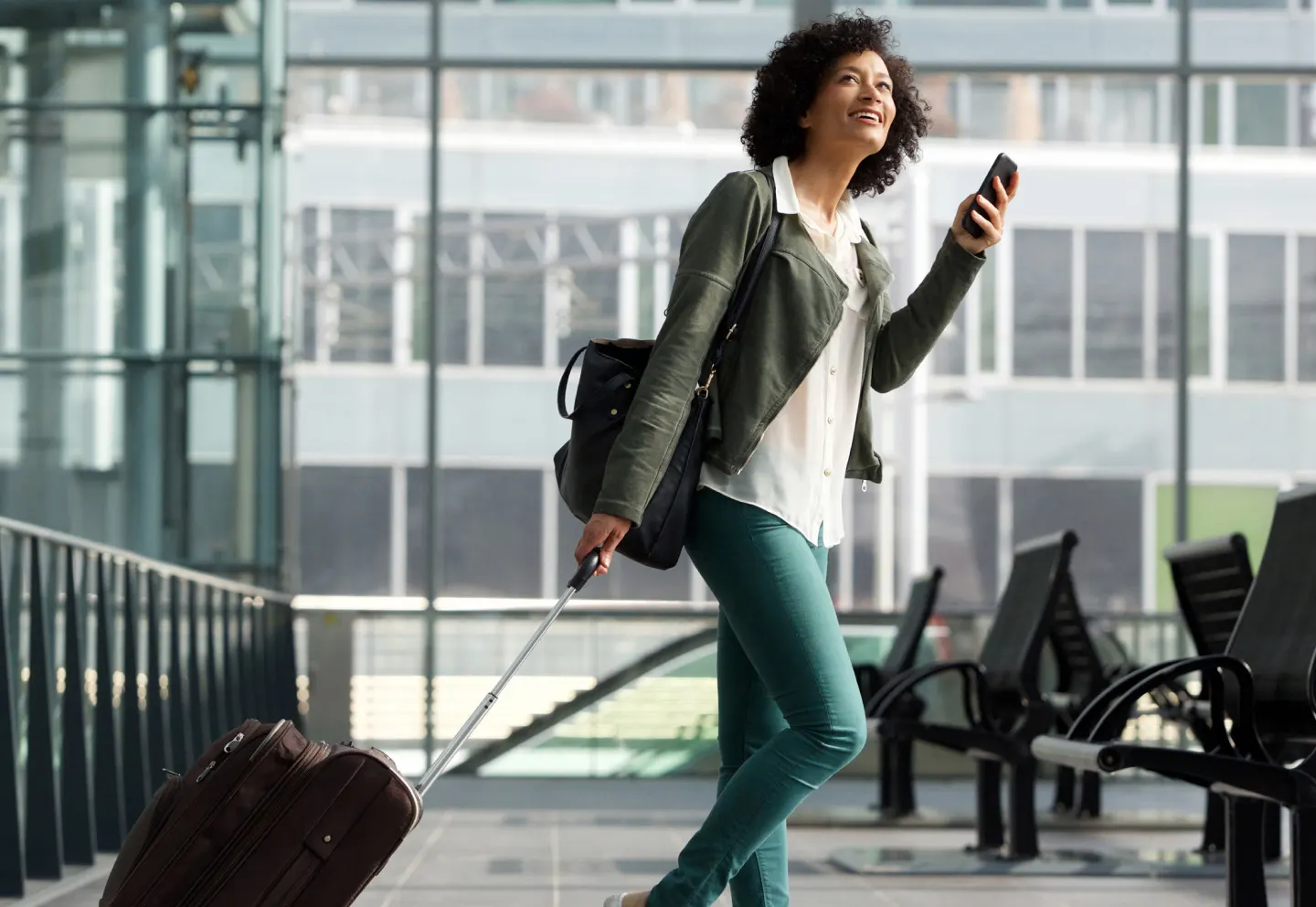 Business woman holding a phone at airport
