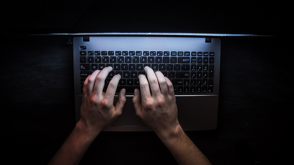Person using laptop on dark web