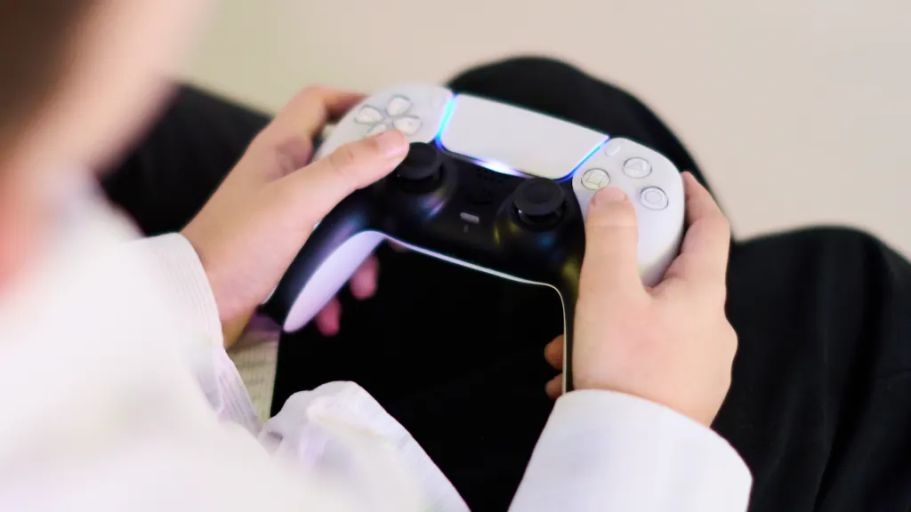 Close up of young hands holding a Playstation 5 controller