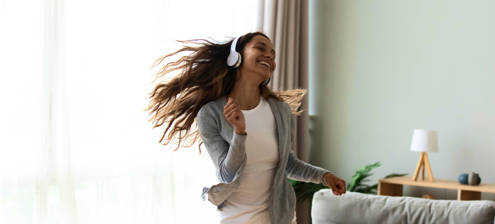 young woman wearing headphones and dancing