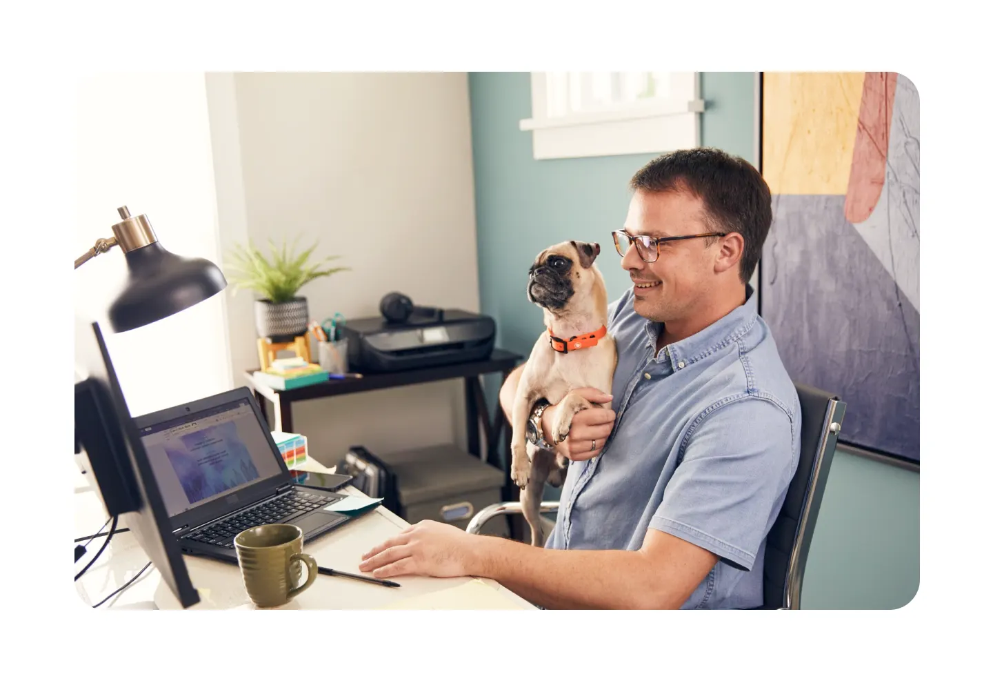 Remote worker using a laptop in a home office with a pet dog, illustrating flexible work-from-home productivity and modern home office life.