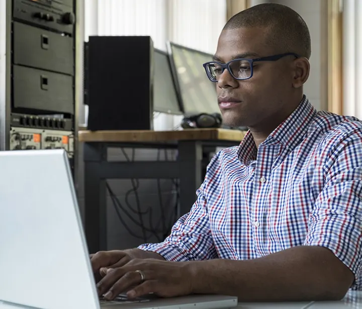 male typing on laptop