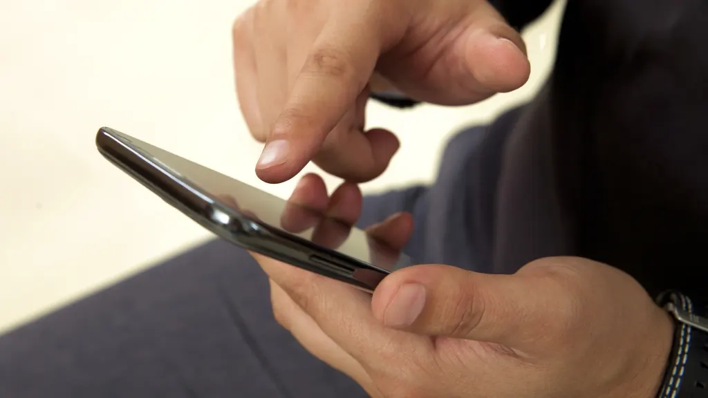 Close-up of masculine hands holding and interacting with a black smartphone