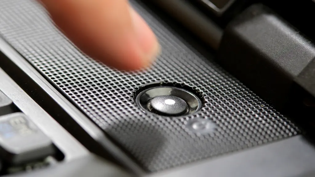 Close up of finger hovering over the power button of a laptop